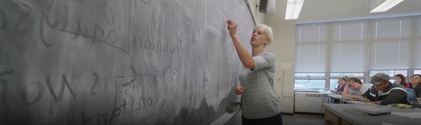 professor writing on a blackboard